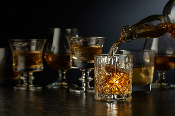 Whiskey is poured from a bottle into a glass.