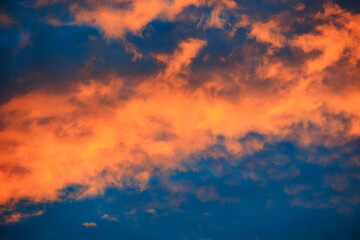 Orange glowing evening clouds in the sky above the Brunnenbach in the forest near Augsburg Siebenbrunn