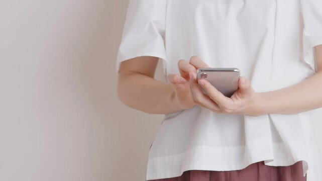 Woman looking at smartphone. Woman scrolling through her smartphone. スマホを見ている女性。スマートフォンをいじったり、スクロールしている女性。