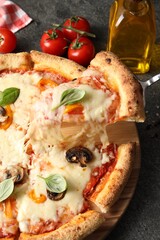 Taking piece of delicious vegetarian pizza at grey table, closeup