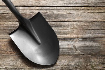 Metal shovel on wooden table, top view. Space for text