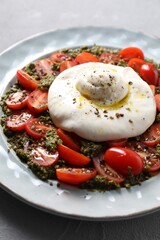 Fresh delicious burrata salad on light grey table, closeup