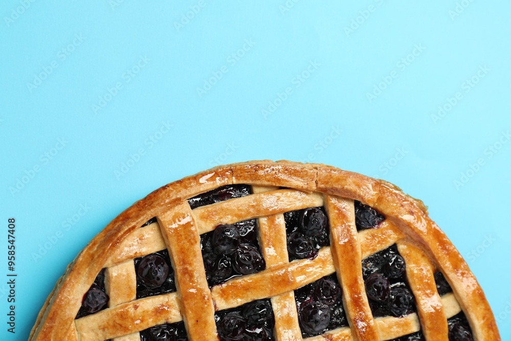 Poster Tasty homemade pie with blueberries on light blue table, top view. Space for text