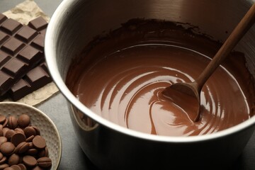 Chocolate dough in bowl and ingredients on grey table, closeup