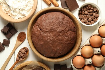 Chocolate dough and ingredients on white wooden table, flat lay