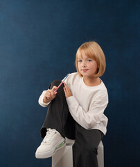 A blonde girl is photographed for a school album in a studio with a movie camera
