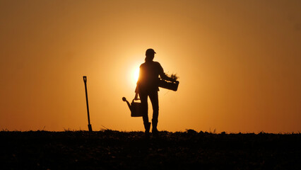 Amidst the sunset's glow, the silhouette of a woman farmer is seen in a field, her figure outlined...