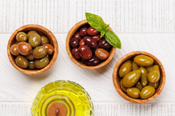 An assortment of various olives presented in a bowl, showcasing different colors, textures, and...