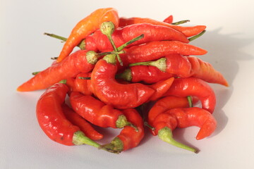 close up and top view heap of fresh bunch ripe red hot chili peppers isolate on a white background. food concept herbs vegetables healthy