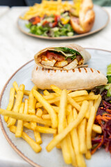 Halloumi wraps with roasted chickpeas, tomatoes and minty yoghurt sauce. These wraps are super tasty, filling and great for lunch or dinner. Served together with french fries and vegetable salad