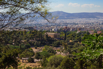 Obraz premium The ancient Greek temple of Hephaestus in ancient Agora in Athens as seen from the top of Acropolis hill in Greece