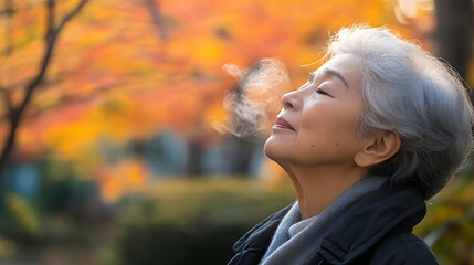 Japanese elderly woman breathing a fresh air in the park, meditation