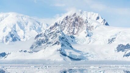 Majestic snow-covered mountains in Antarctica rise above the icy plains, creating a stunning frozen landscape