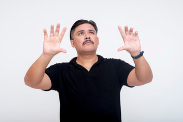 A stocky middle-aged man of mixed race interacting with a virtual screen or menu using his hands. For further editing purpose. Set against a white background.