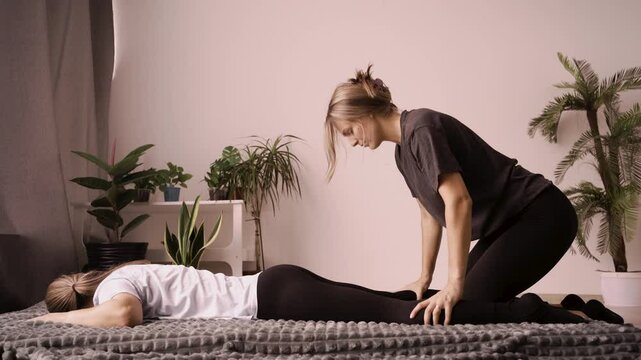 Masseuse using Japanese techniques Yumeiho pressure on woman legs making therapeutic massage. Yumeiho therapy and shiatsu massage concept