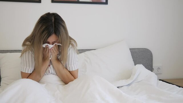 Sick woman sits on bed, coughing into tissue, visibly struggling with illness. Scene captures essence of illness, highlighting symptoms. Ideal for content on health, disease, or illness awareness. - Powered by Adobe