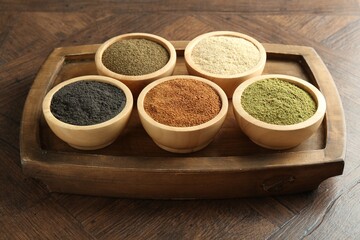 Different superfood powders in bowls on wooden table