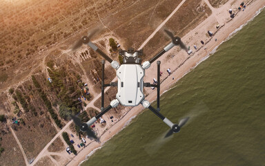 Drone (quadcopter) observer with action camera. Coastal zone control. Flying over the sea and the...