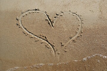 A heart drawn on wet sand. Love and feelings.