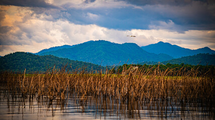 Evening sun rays with rain clouds forming over Thap Salao Dam, Uthai Thani Province, Thailand.
