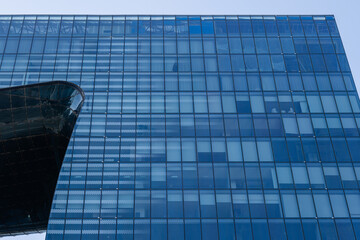 Huge building facade with curved glass reflecting sky. Contemporary office architecture design