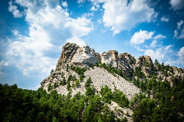 Mount Rushmore National Monument memorial in South Dakota with blue sky and cumulus clouds