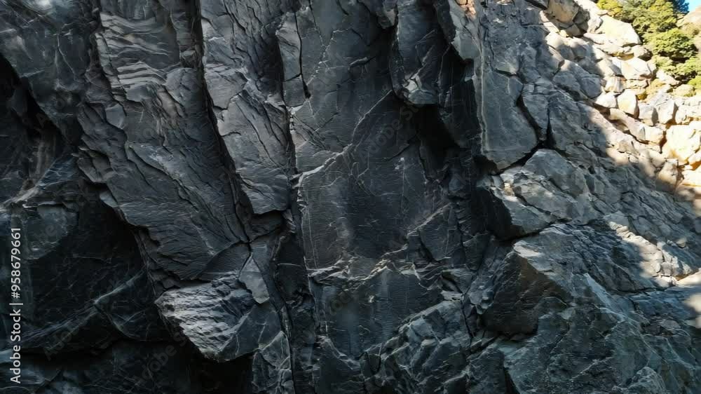 Poster Close-up of a rugged slate rock wall, featuring textured surfaces with sharp layers and deep grooves.