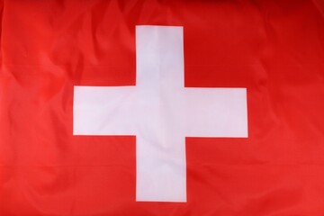 The national flag of Switzerland displaying its iconic red background and white cross in a simple yet bold design