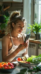 A young woman smiles at her smartphone in a bright kitchen, surrounded by vegetables like tomatoes and cucumbers, creating a welcoming atmosphere.