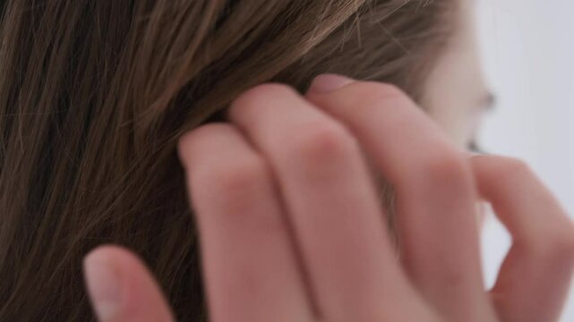 Close-up of a woman's hand tucking her long hair behind her ear