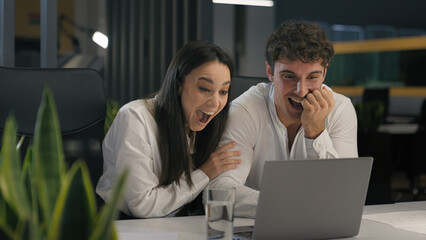 Happy excited winners successful business colleagues winning with pc hugging rejoice people Caucasian businesswoman with businessman woman with man computer laptop in office win achieve hug triumph