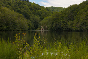 Una antigua construcción se asoma a las orillas del embalse de Santa Fe, rodeada de un espeso...