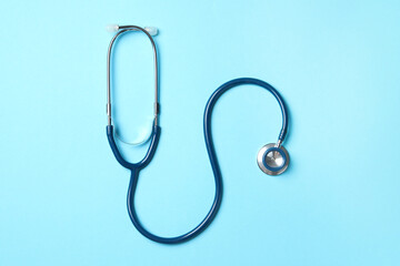 Stethoscope on light blue background, top view. Medical treatment