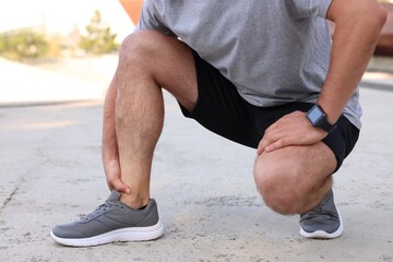 Naklejka premium Man suffering from foot pain outdoors, closeup