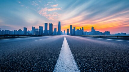 Obraz premium Asphalt Highway Leading to a Skyline at Sunset