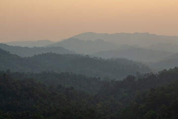 Aerial panorama of hills and orange sky in jungle at sunset. Laos
