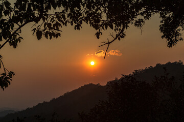 Aerial panorama of hills and orange sky in jungle at sunset. Laos