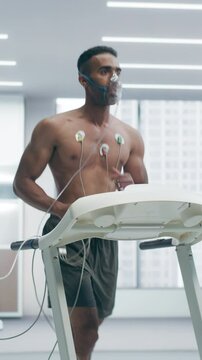 Vertical Screen. Athletic Individual Wearing Headset for Cardiopulmonary Testing on High-tech Treadmill. Subject Wears Oxygen Mask and Ecg Electrodes. Sports Science and Medical Diagnostics