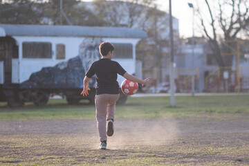 Obraz premium Niño practicando fútbol al aire libre