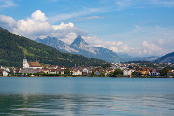 small old town on the coast of the lake with mountain peaks in the background