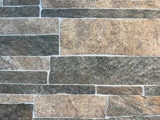 Natural random brick style stone texture with brown earth tone colors. Cobble stone and flag stone flattened slab cut.