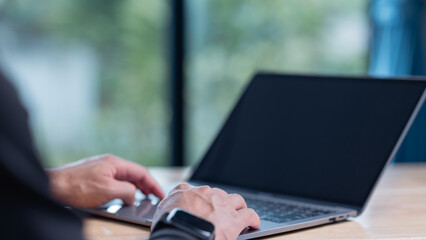 A close-up shot of hands typing on a laptop, showcasing modern work culture and digital engagement in a serene environment, emphasizing productivity and technology integration in daily life