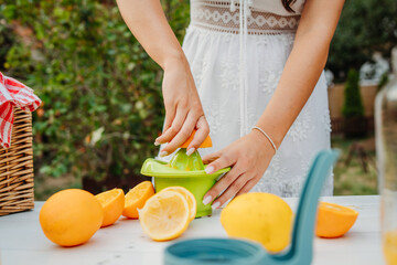 Close up of woman's hands using hand juicer for orange and lemon