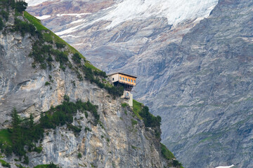 mountain hut on a vertical cliff in the alps. climbing and hiking concept