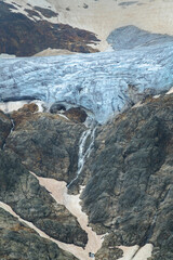 a blue glacier within rocky mountain lanscape. climbing and trekking 