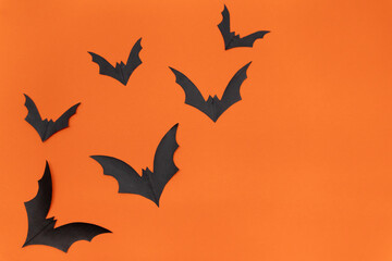 Fototapeta premium Halloween background - Black bats on bright orange background. Halloween atmosphere.