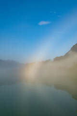 misty rainbow effect from lake. travel and weather concept