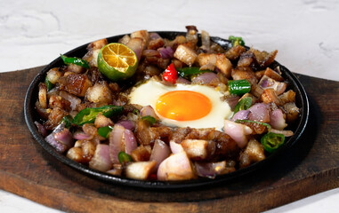 Sisig is a Filipino dish made from pork jowl and ears, pork belly, and chicken liver, which is usually seasoned with calamansi, onions, and chili peppers.