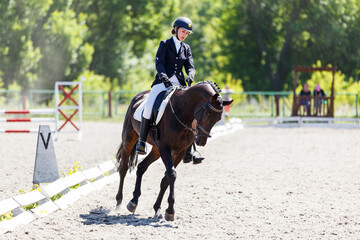 Young equestrian girl performing her dressage test in equestrian competition