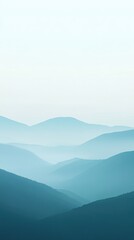 Naklejka premium Serene landscape featuring soft, layered hills enveloped in mist. A tranquil scene perfect for relaxation and nature themes.